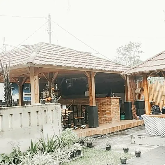 Open-air pavilion with a timber roof, a brick counter and wooden tables