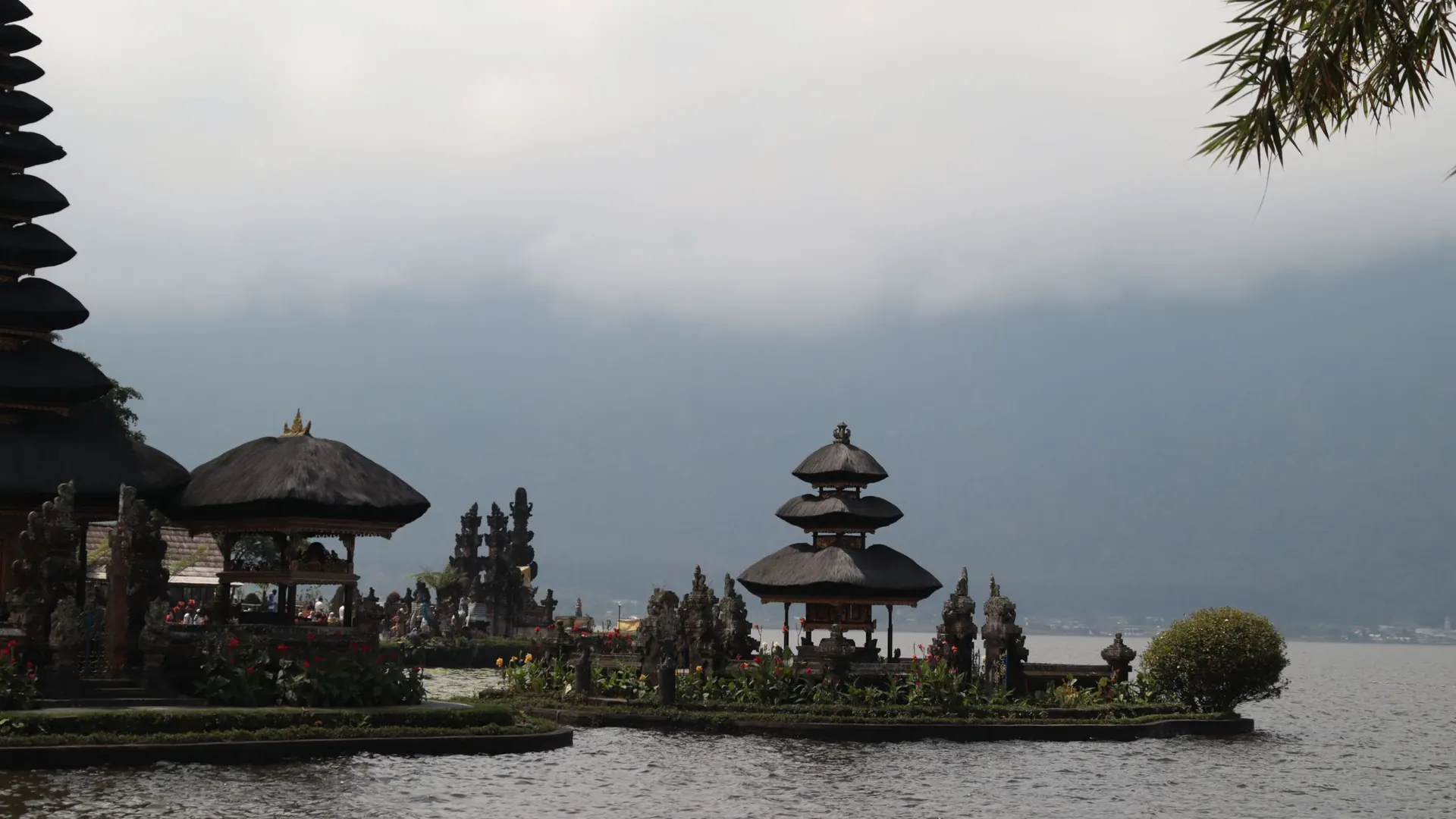 Temple shrines on the shore of Lake Beratan under grey cloud